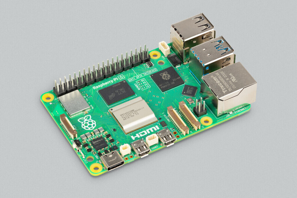 Плата Raspberry Pi 5 с портами USB, Ethernet и micro-HDMI на сером фоне