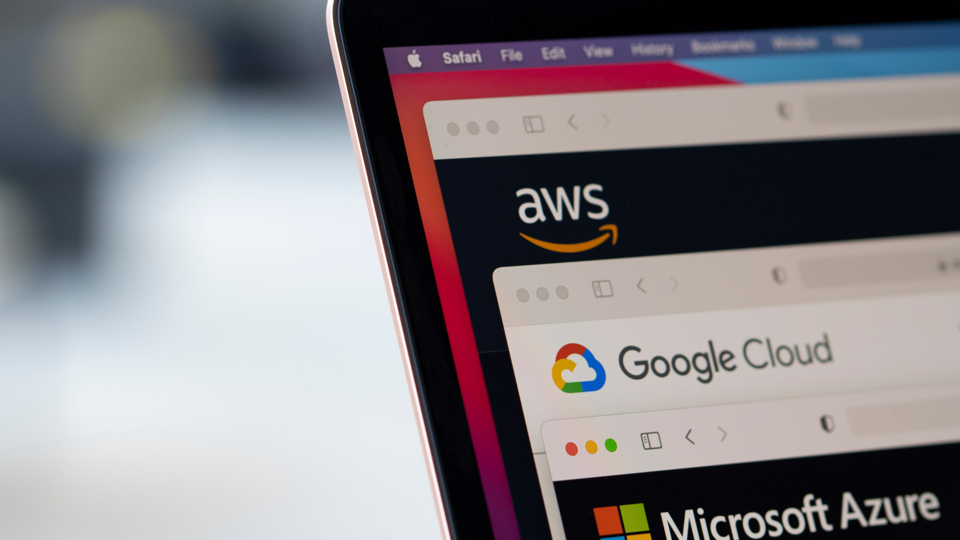 Close-up of a laptop screen showing AWS, Google Cloud, and Microsoft Azure logos in a browser window.