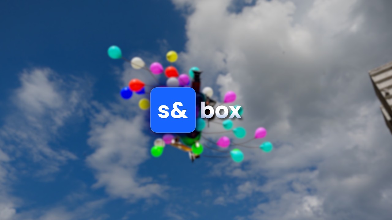 S&box logo centered on a backdrop of colorful balloons in a blue sky behind it.