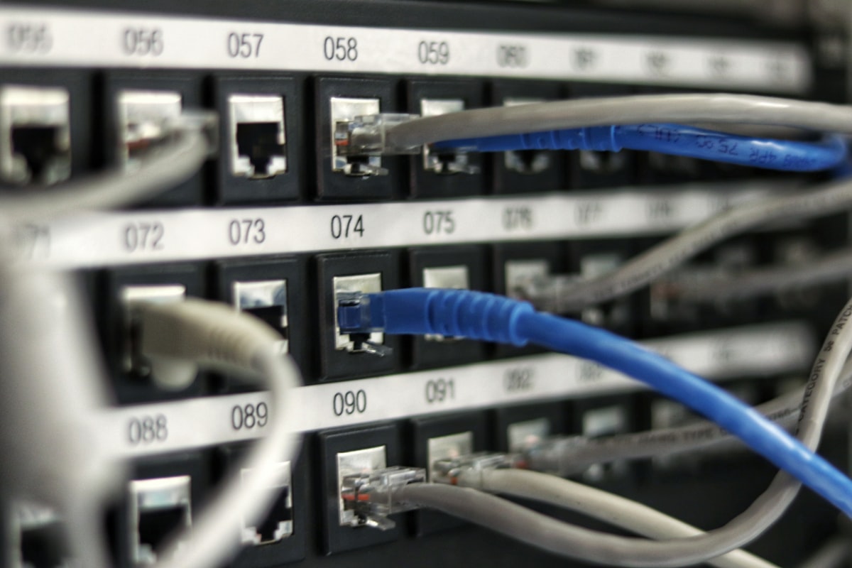 Close-up of a network switch with numbered RJ-45 ports and several Ethernet cables plugged in.