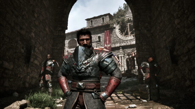 Central armored warrior confronts the camera in a ruined stone courtyard, with other armored soldiers in the background.