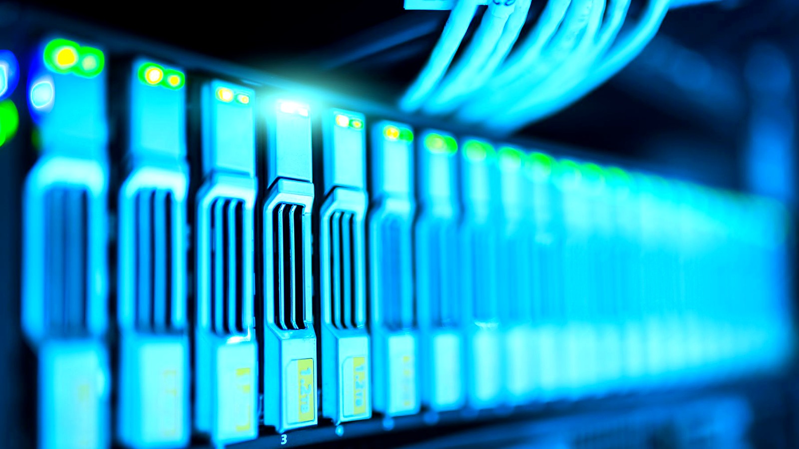 Row of blue-lit server racks in a data center with green status LEDs indicating activity.