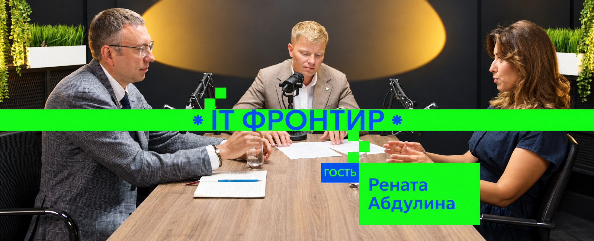 Podcast recording session with three people at a wooden table and professional mics; green branding banner across reads IT ФРОНТИР and guest name Рената Абдулина framed by plants in the studio.